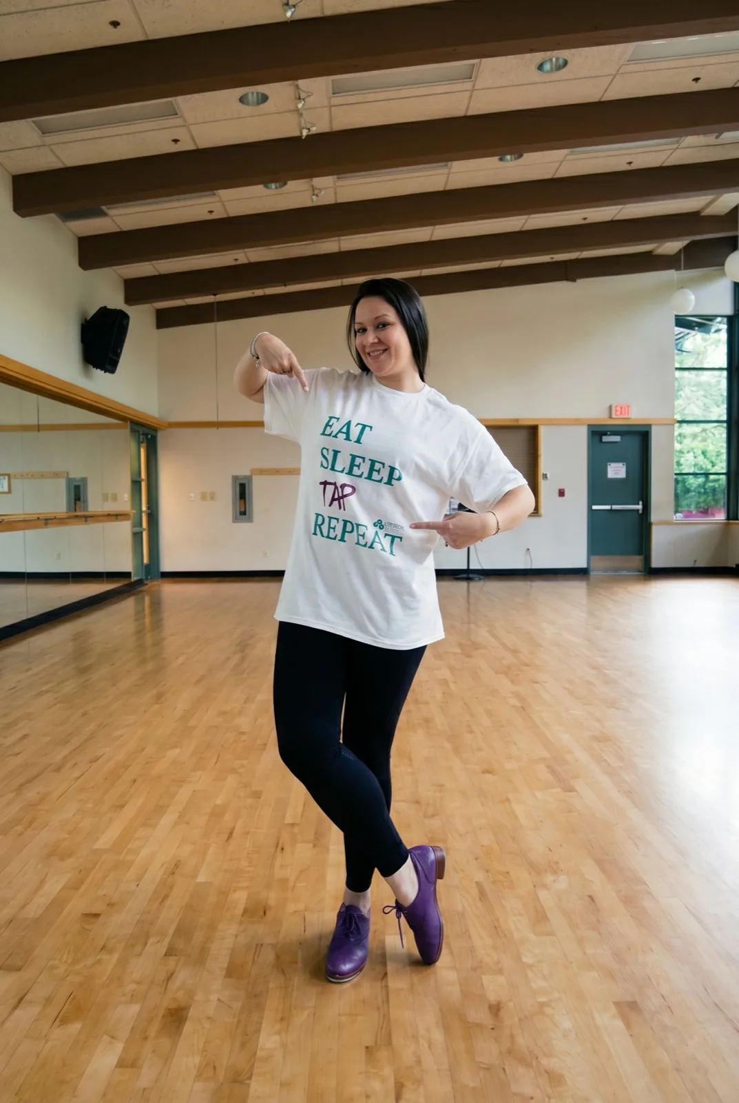 Bailarina em estúdio vestindo camiseta Eat Sleep Tap Repeat da marca Andrea Pito
