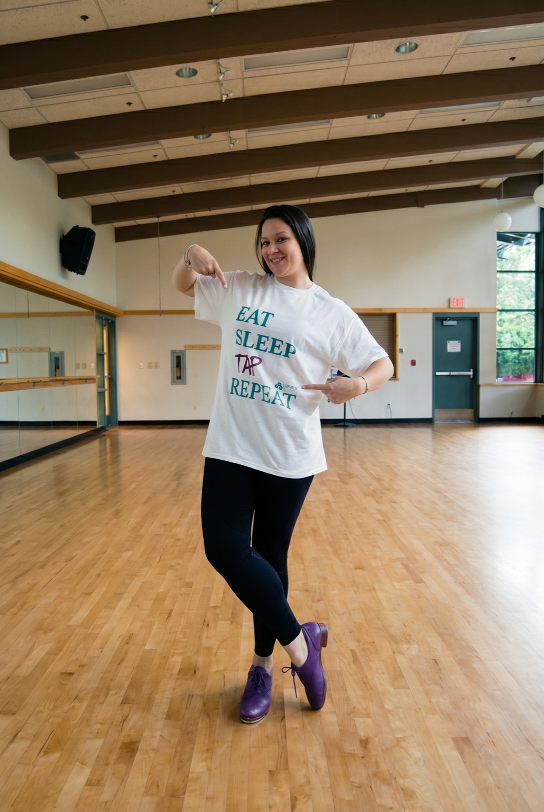 Dancer in a studio wearing the Eat Sleep Tap Repeat shirt by Andrea Pito