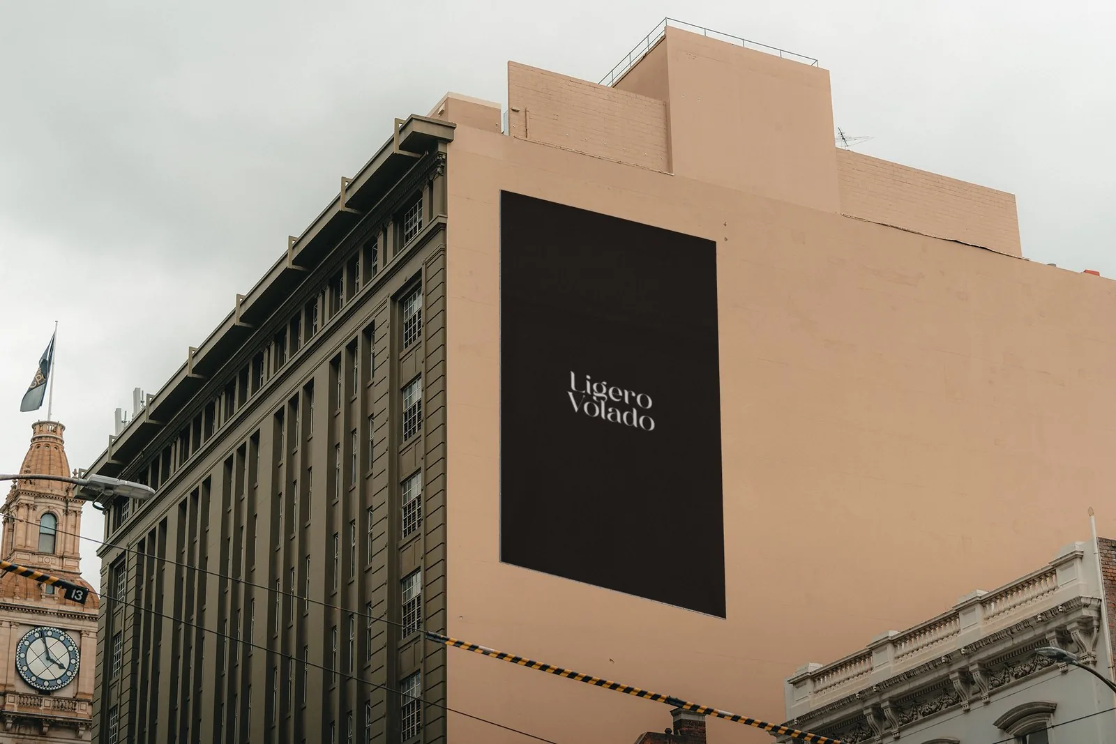 Painel externo com o logotipo Ligero Volado em fachada de edifício em tom terracota