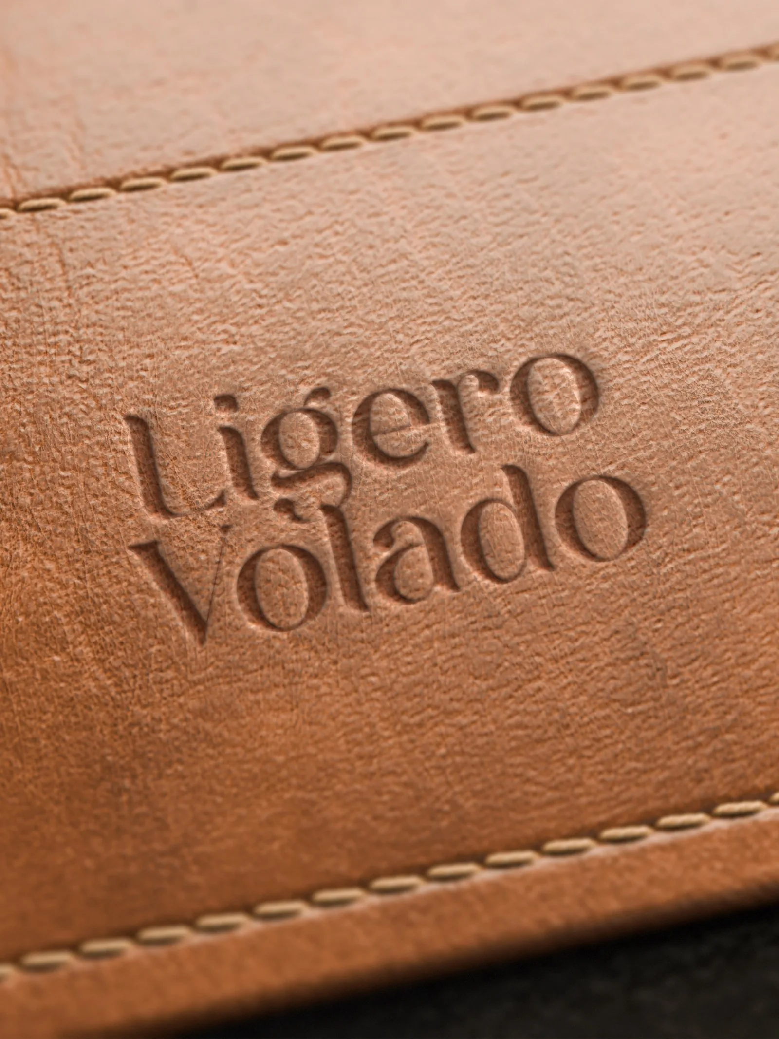 Logotipo Ligero Volado gravado em relevo sobre couro caramelo costurado