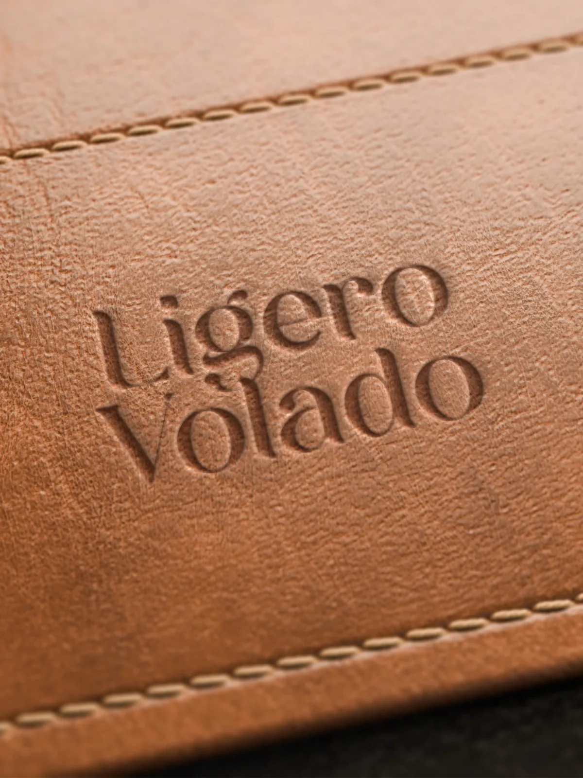 Logotipo Ligero Volado gravado a seco em couro caramelo costurado